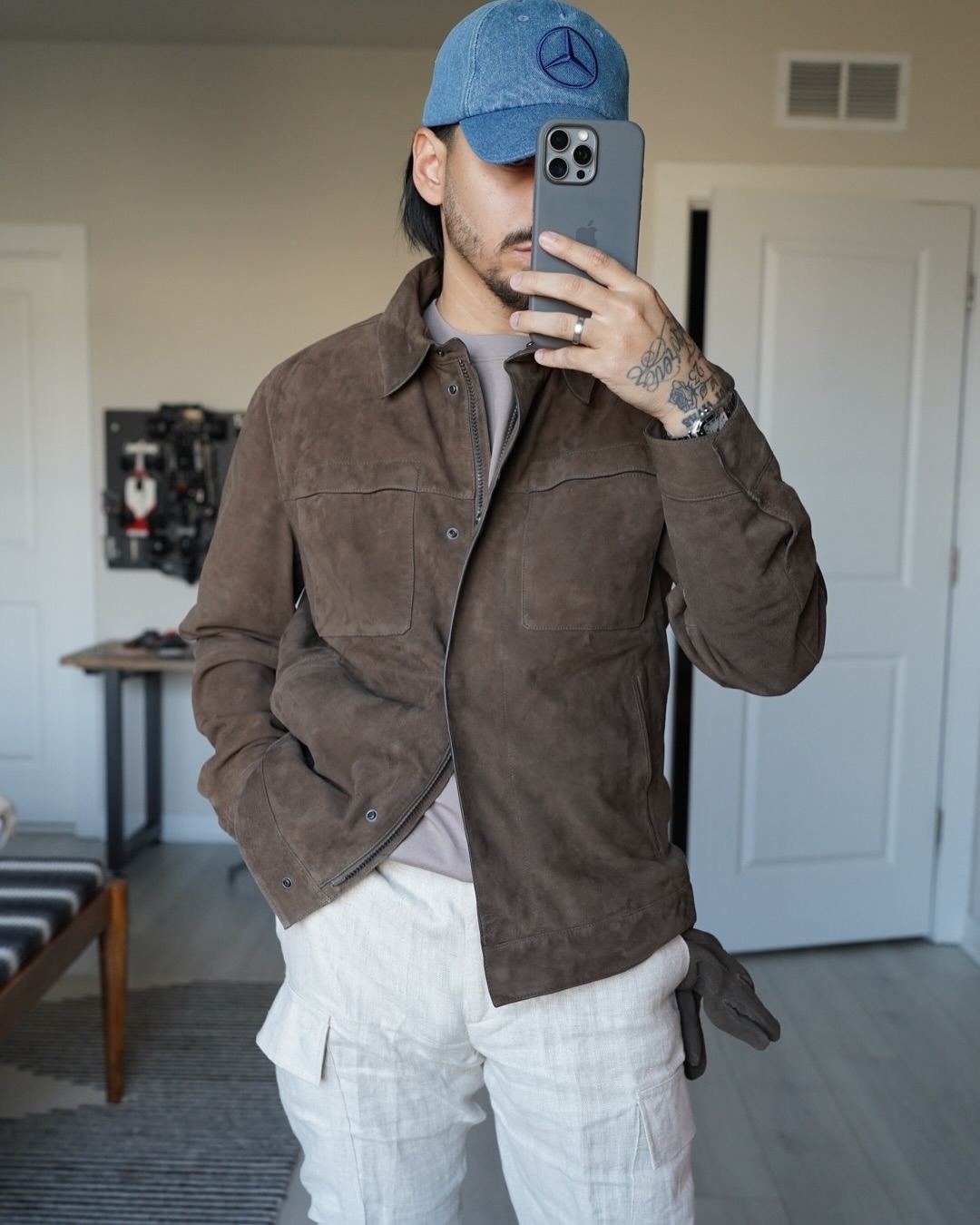 Rob in a brown suede trucker jacket and white cargo pants